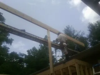 Carpenter setting a ridge beam over a new addition frame — Ice Dam Removal by Roofing Brothers in Poplarville