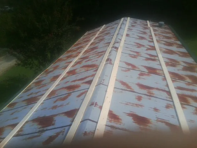 Rusted metal roof panels with new wood purlins before replacement — Storm Damage Roof Repair in Poplarville by Roofing Brothers