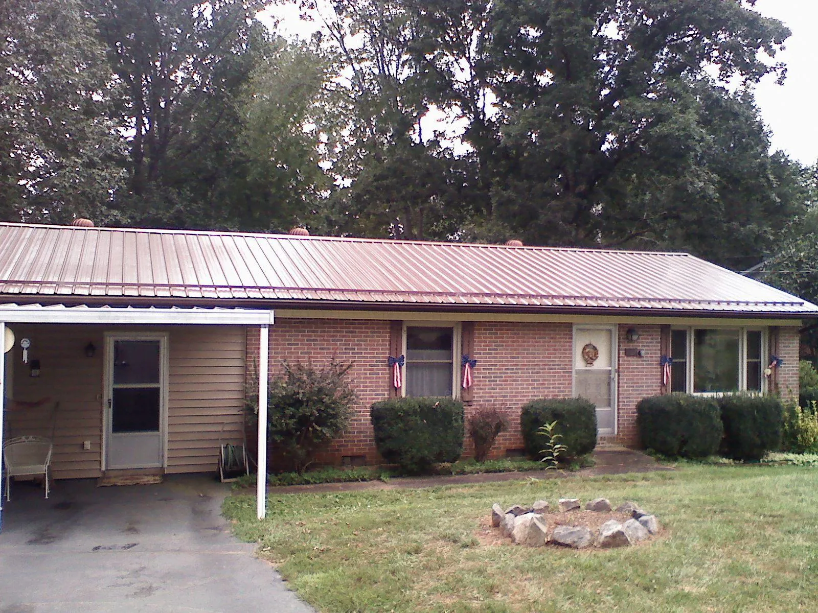 Bronze metal roof and carport on a brick ranch home — Roof Repair work by our crew in Poplarville