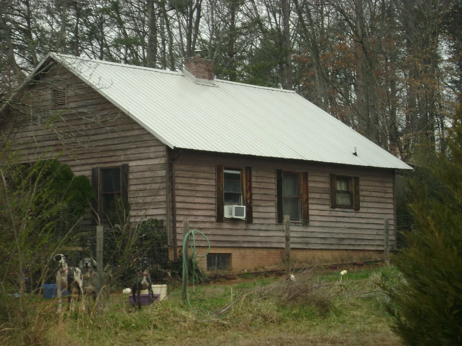 White metal roof on an old wood sided farmhouse, from a Asphalt Shingle Roof Repair job in Poplarville